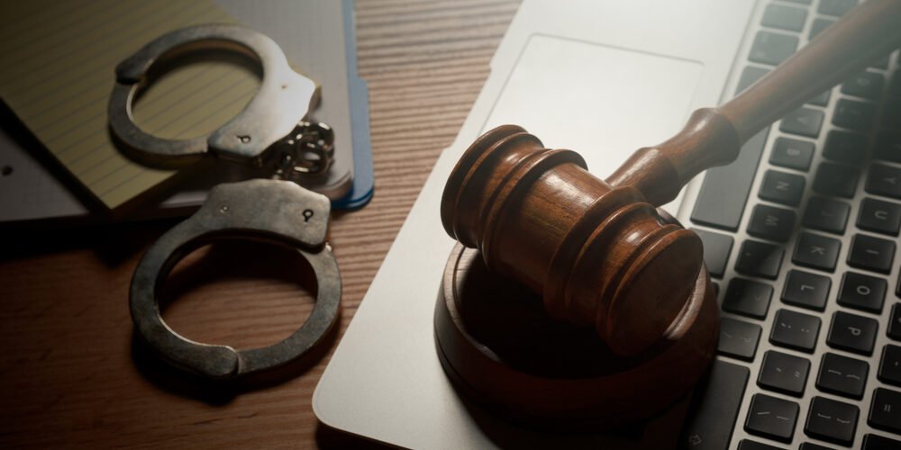 Judge gavel and laptop on wooden table