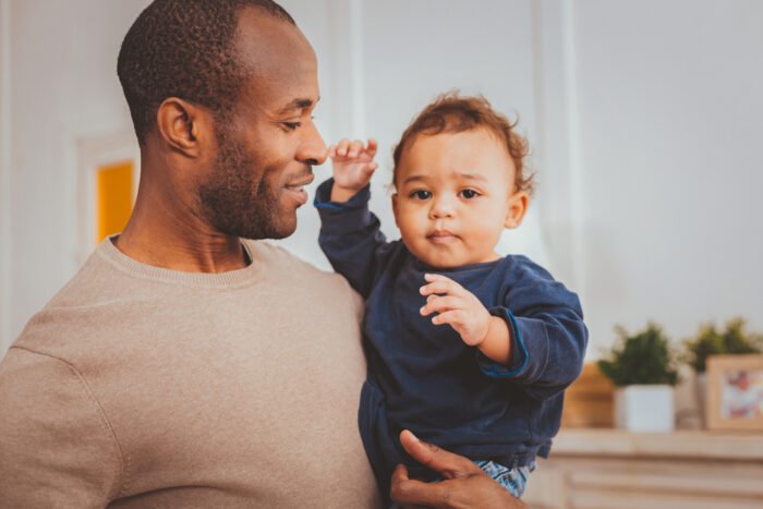 Cheerful father holding his little son