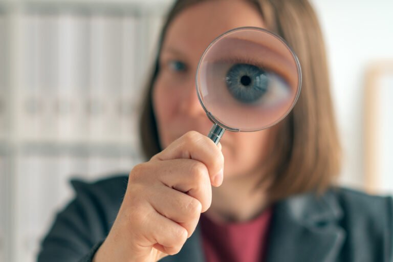 Businesswoman with magnifying glass doing business financial aud