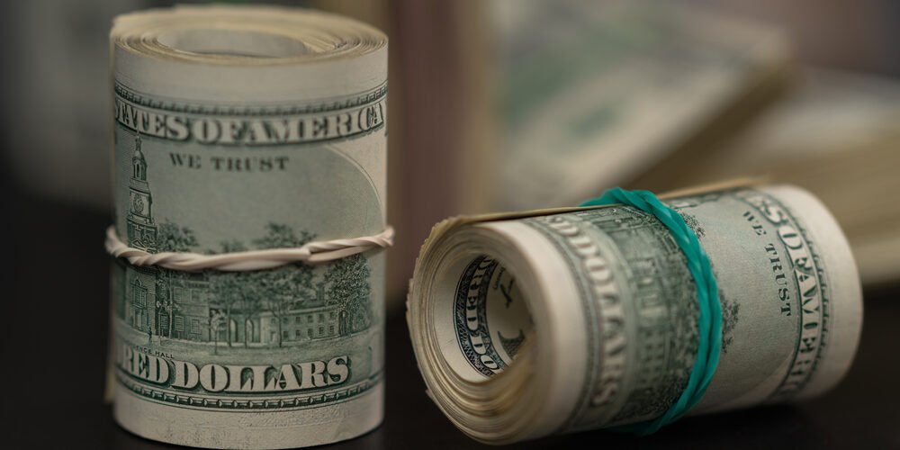 Rolls of rolled USD bills tied with rubber bands
