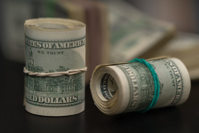 Rolls of rolled USD bills tied with rubber bands