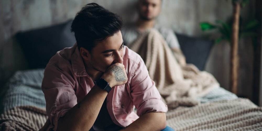 Young gay couple in quarrel at home. LGBT concept