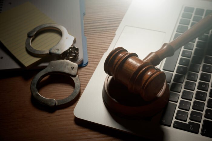 Judge gavel and laptop on wooden table