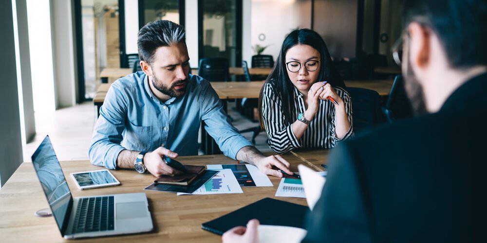 Man explaining idea to colleague A couple discussing divorce mediation options with a neutral third-party mediator in a private setting.