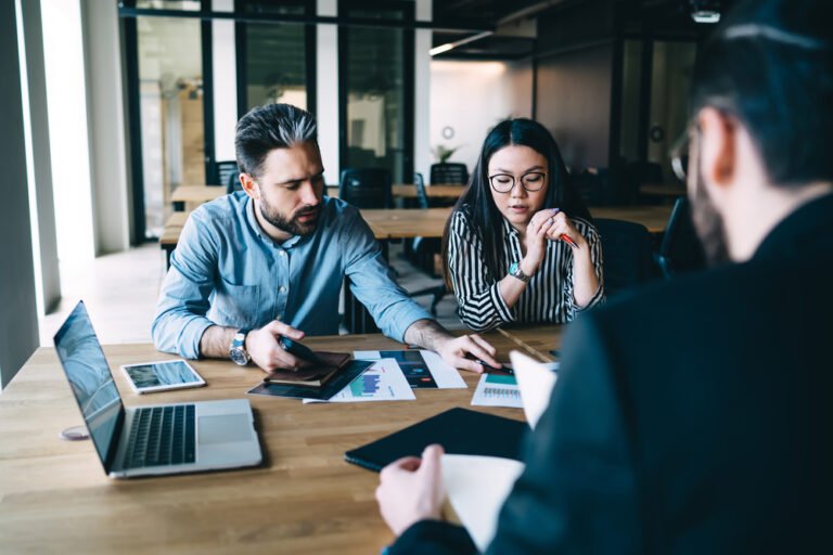 Man explaining idea to colleague A couple discussing divorce mediation options with a neutral third-party mediator in a private setting.