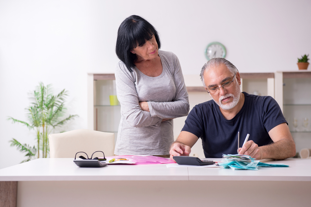 Middle-aged couple reviewing financial documents together at home, representing the process of understanding marital versus separate property during high-asset divorces.