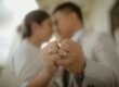 A couple holding up wedding rings.