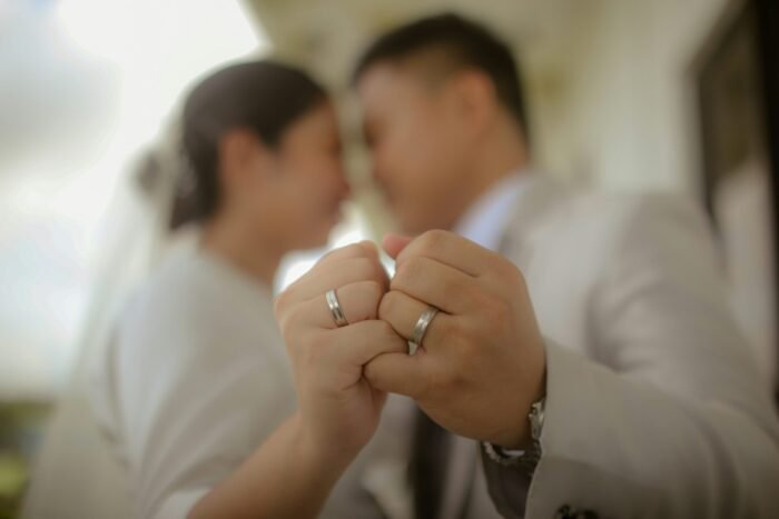 roxanne-andrea-dychengco-jCTZH8A1x6o-unsplash A couple holding up wedding rings.