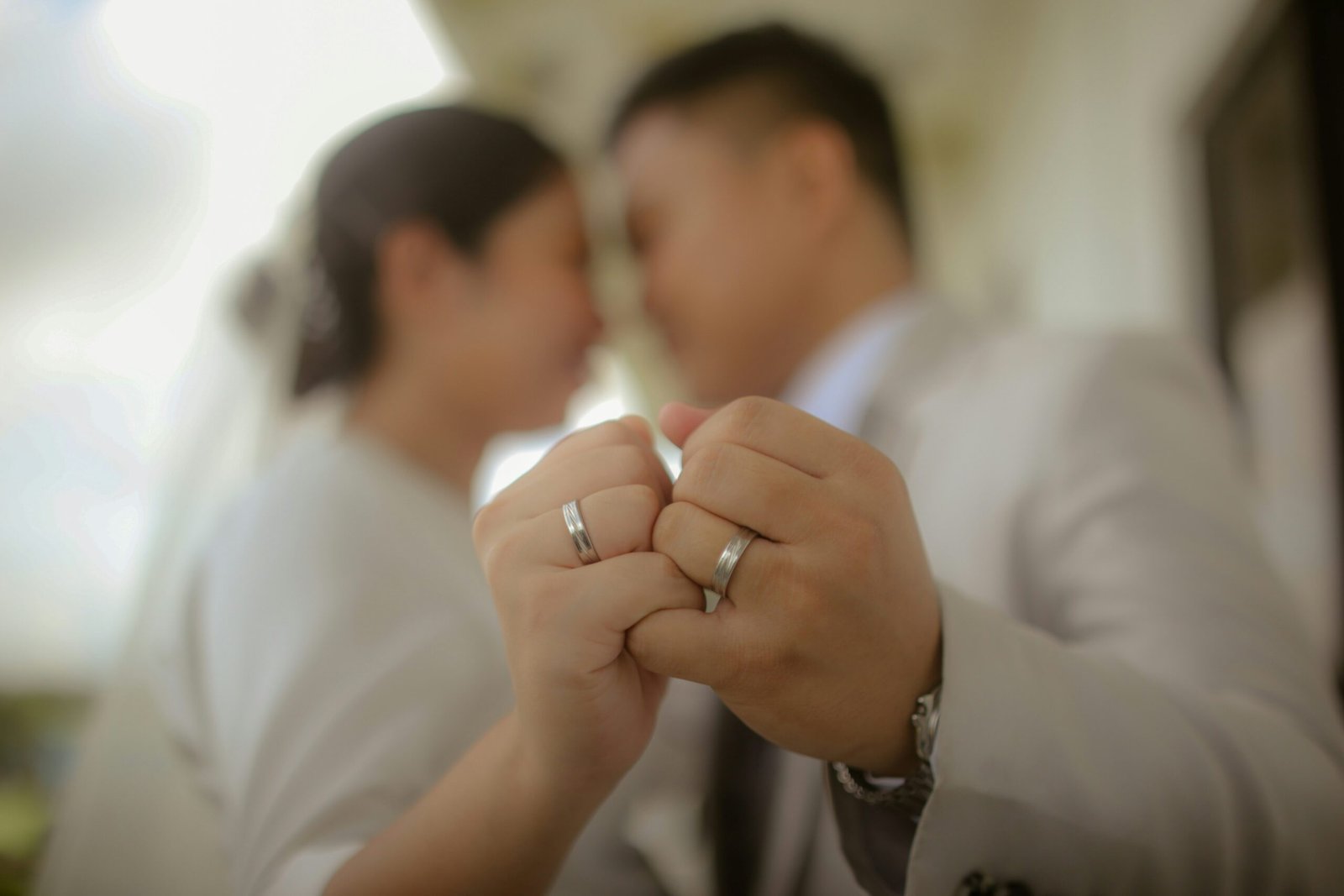 A couple holding up wedding rings.